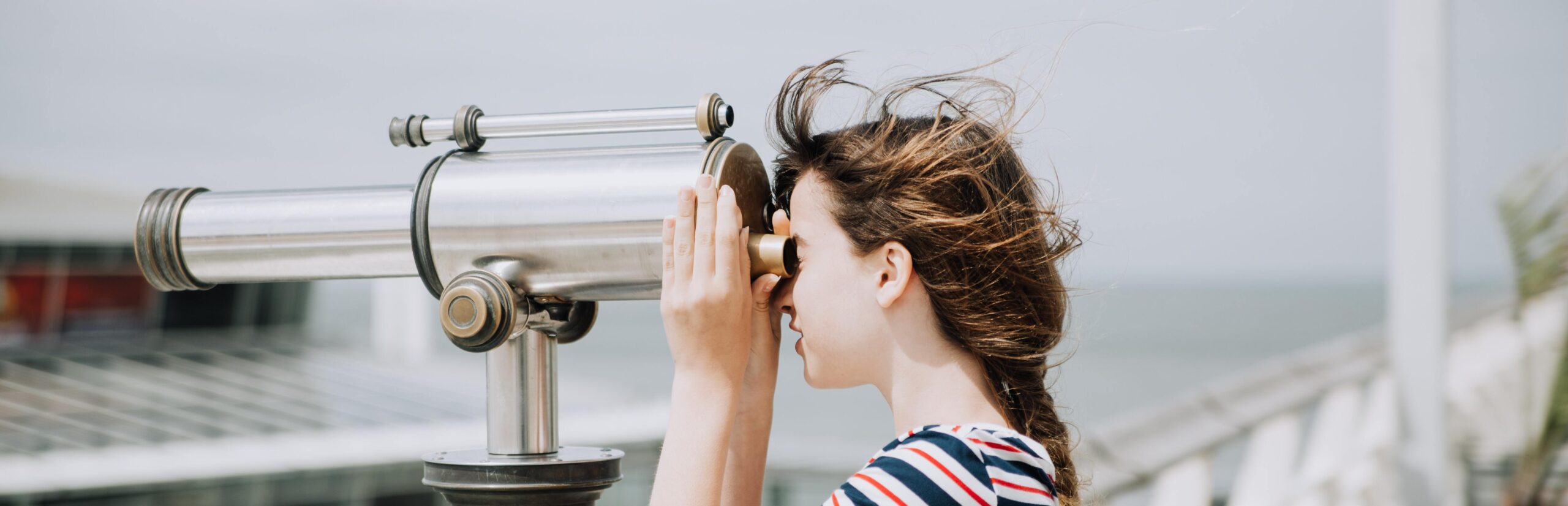 A cover photo of a girl looking through a telescope